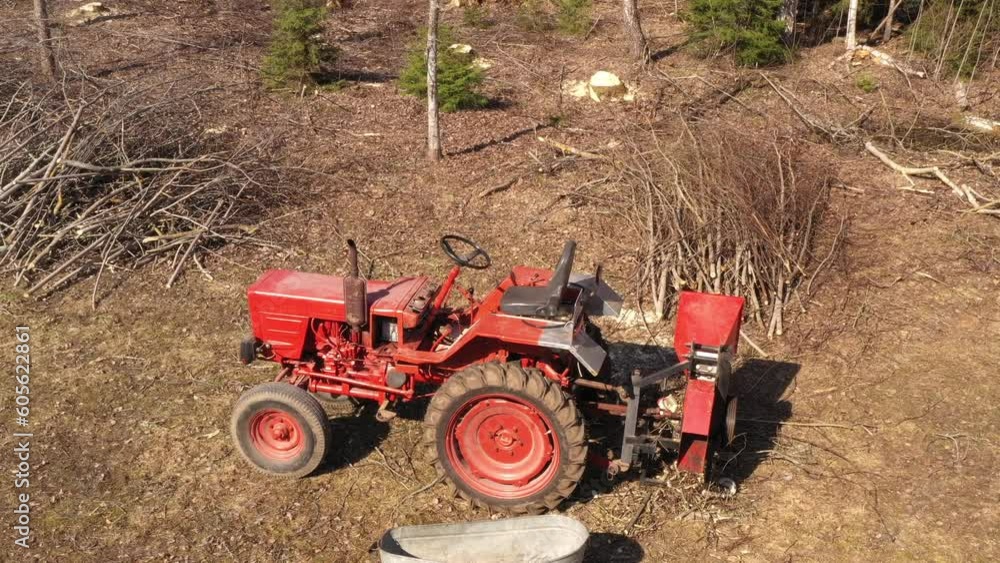 Aerial view of t25 tractor with branch shredder mechanism in forest Aerial view of t25 tractor with branch shredder mechanism in forest