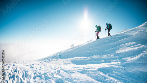 two girls in snowshoes walk in the snow. hiking in the mountains in winter.