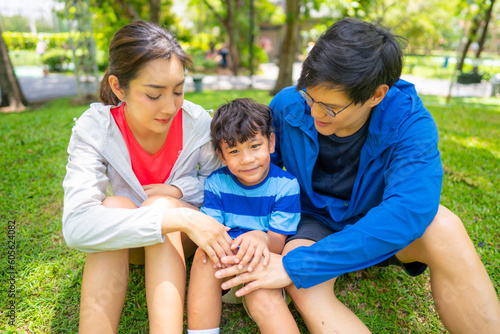 Happy Asian parent and little kids enjoy and fun outdoor lifestyle on summer vacation. Father, mother and child playing and relaxing together at park. Family relationship and health care concept. © CandyRetriever 