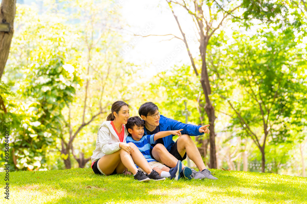 Fototapeta premium Happy Asian parent and little kids enjoy and fun outdoor lifestyle on summer vacation. Father, mother and child playing and relaxing together at park. Family relationship and health care concept.