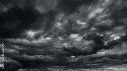 Fototapeta Naklejka Na Ścianę i Meble -  dark dramatic sky with black stormy clouds before rain or snow as abstract background, extreme weather, the sun shines through the clouds, high contrast photo