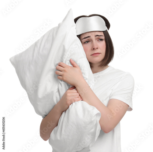 Unhappy young woman with sleep mask and pillow on white background. Insomnia problem