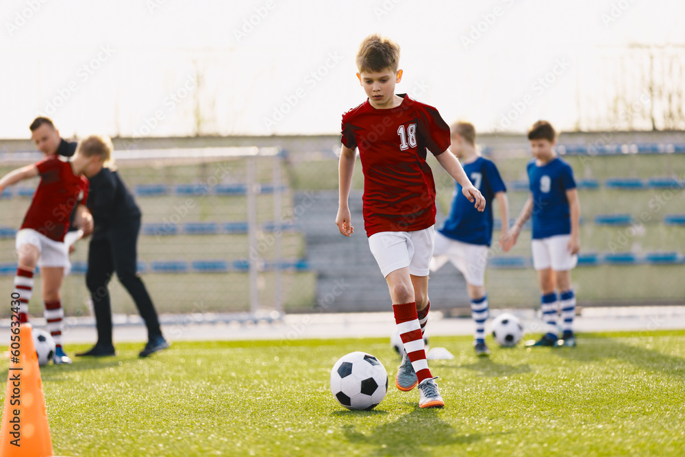 Training action of boys soccer teams, aged 10-12, playing at football practice pitch. School soccer team at a training session with a coach Training action of boys soccer teams, aged 10-12, playing at football practice pitch. School soccer team at a training session with a coach