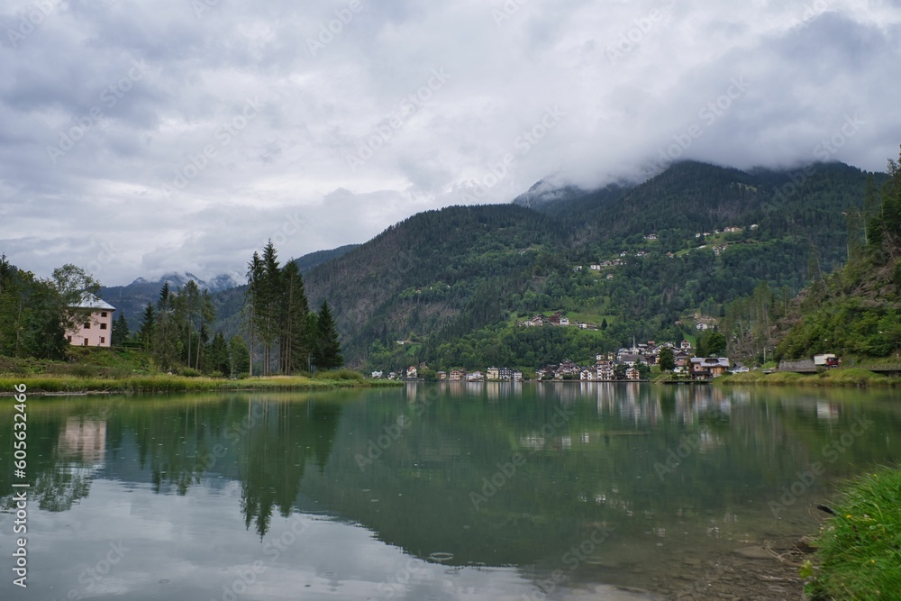 Lake surrounded by trees and mountains on a cloudy day