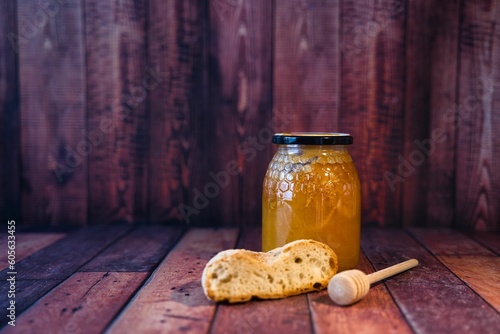 Closeup of a honey jar and bread in a wooden box photo