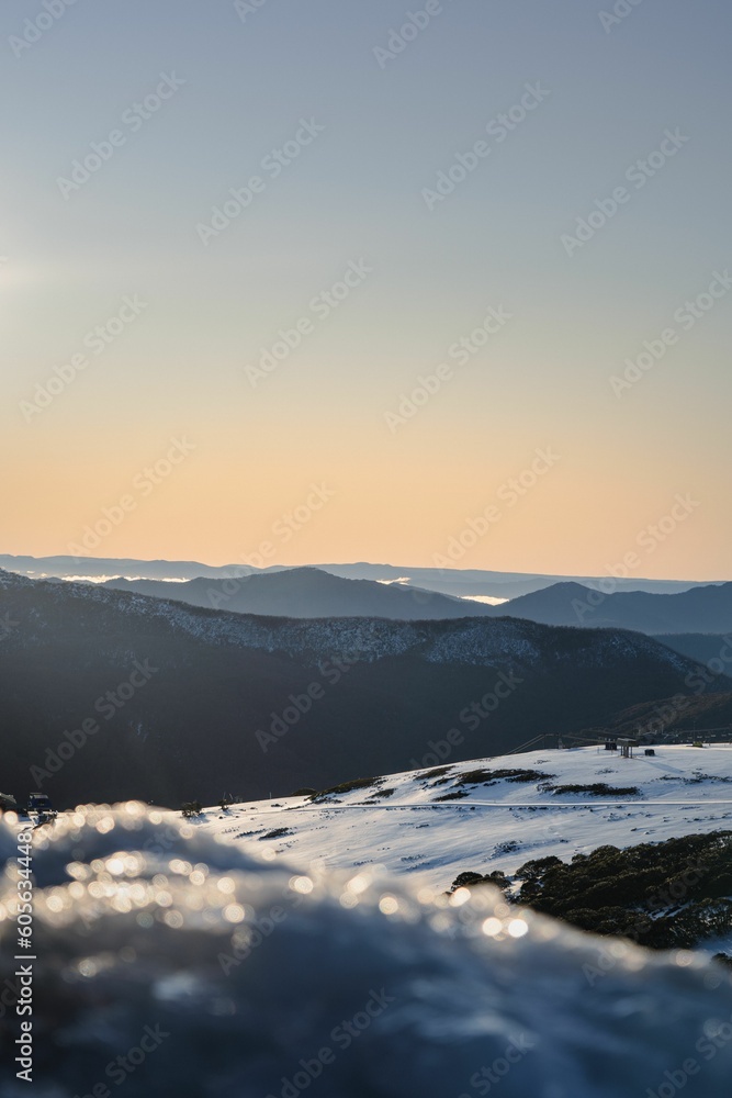 Obraz premium Winter landscape at sunrise with snowy mountains, clear and purple sky background