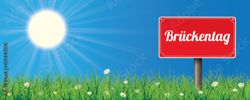 Rotes Schild mit dem Wort Brückentag auf der grünen Wiese