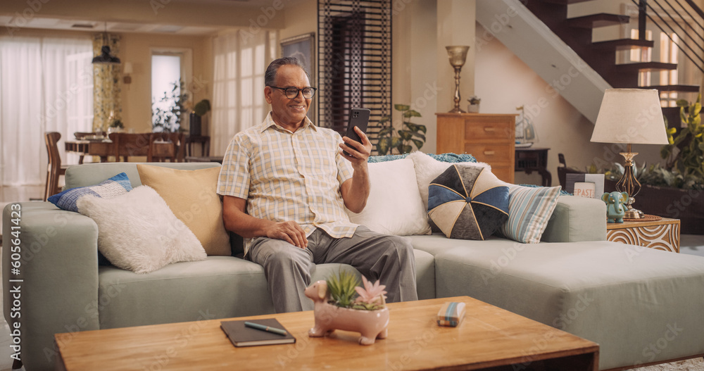 Elderly Indian Man Using Smartphone for Video Call: Cherishing Talks with Loved Ones, Engaging in Meaningful Conversations, and Celebrating Family.Active Grandfather Stays Connected. 