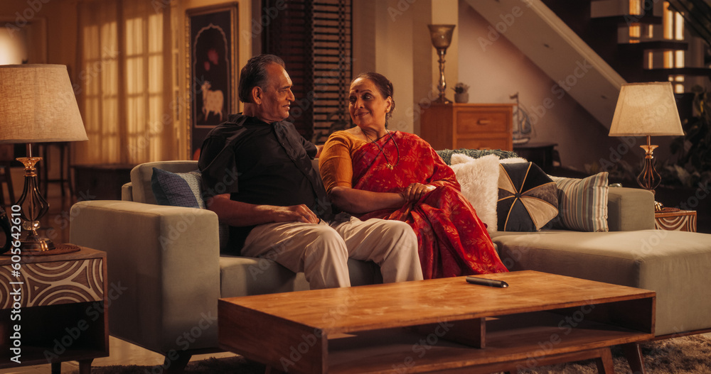Fototapeta premium Blessed Love: Elderly Couple Enjoying a Quiet Evening at Home, Talking and Communicating. Beautiful Indian Husband and Wife Recalling Memories Together in Cozy Living Room, Feeling Nostalgic