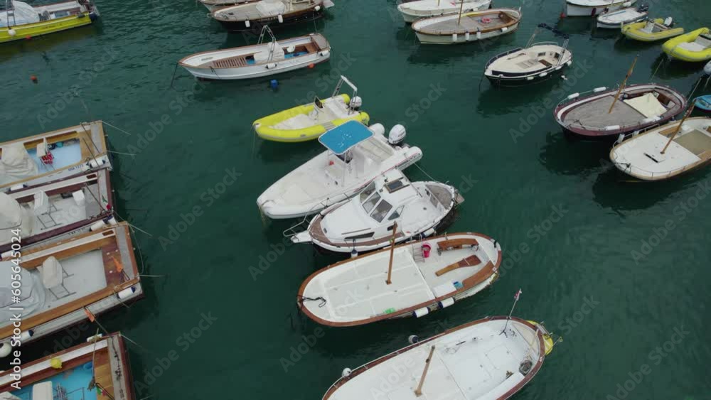 Fishing and speed boats moored at green ocean water port harbor, capri island italy