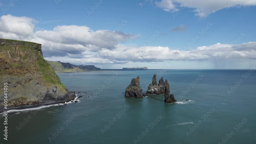 Beautiful blue skies fill the screen as the drone slowly dollies out to reveal more of the famous Black sand beach in Reynisfjara Iceland. Beautiful blue skies fill the screen as the drone slowly dollies out to reveal more of the famous Black sand beach in Reynisfjara Iceland.