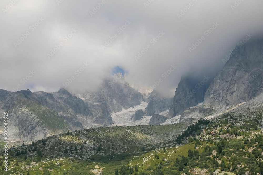 Scenic view of a rocky mountain range with its peaks hidden in the mist