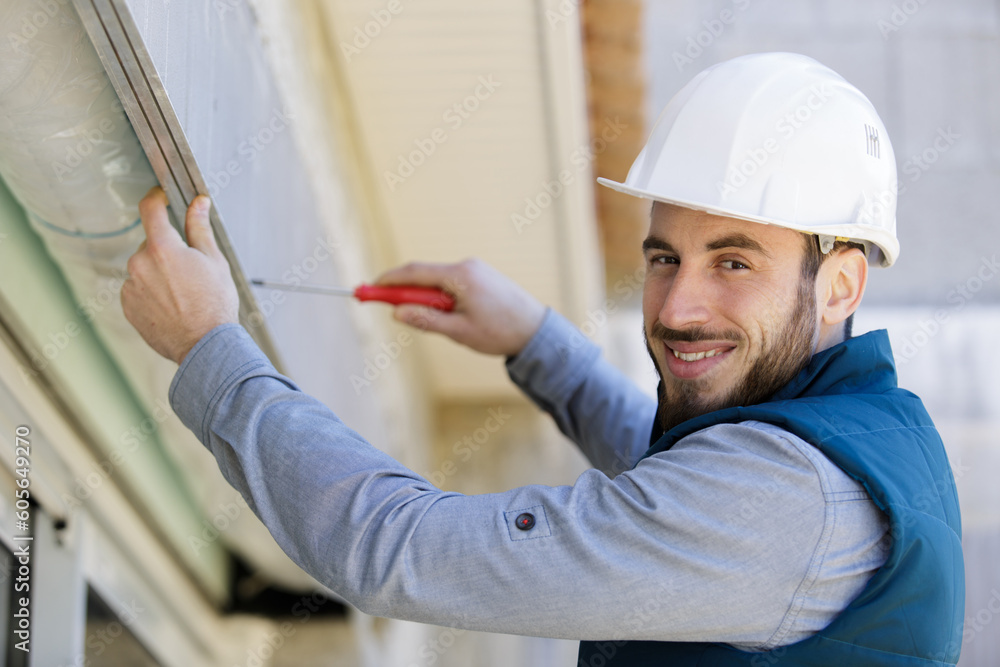 happy young builder is screwing window happy young builder is screwing window