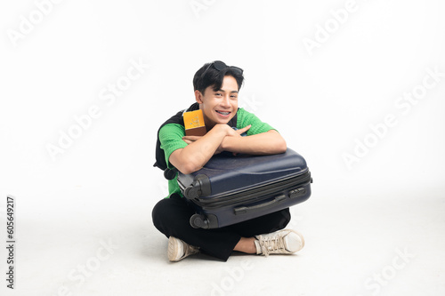 Lifestyle traveling young man happy Asian young man sit hug bag with passport and suitcase on white background