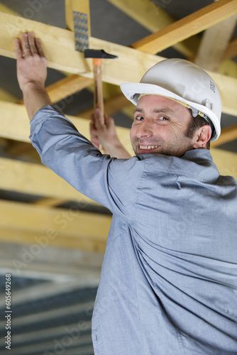 happy man builder hammer wood structure indoors