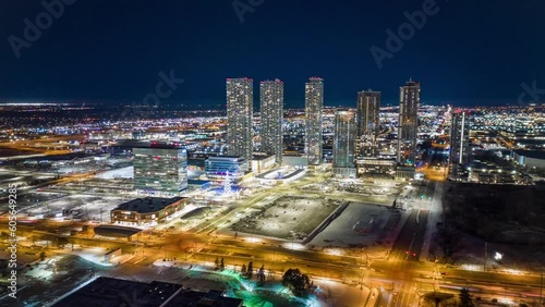 Wallpaper Mural Drone time-lapse view over illuminated high-rise buildings by industrial buildings in the night Torontodigital.ca