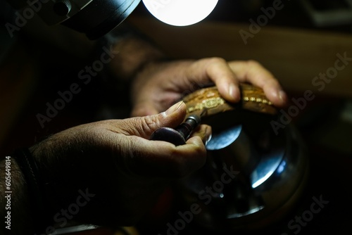 Closeup shot of the hands of a jeweler crafting a handmade gold accessory by manual tools