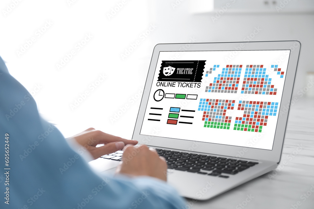 Woman buying theater tickets online via laptop at table, closeup Woman buying theater tickets online via laptop at table, closeup