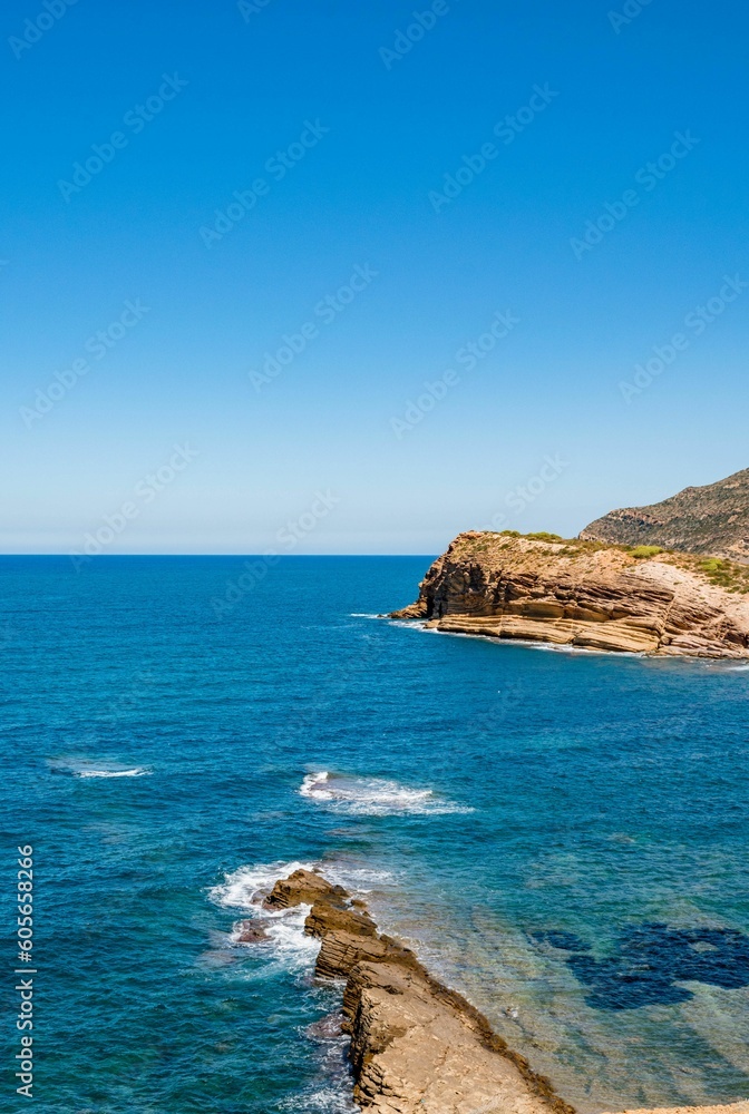 Vertical shot of a seascape with rocky cliffs on the coast of Korbous, Tunisia