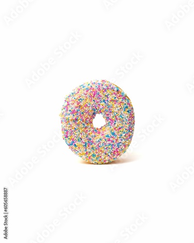 Creamy vanilla donut with colorful sprinkles isolated on a white background