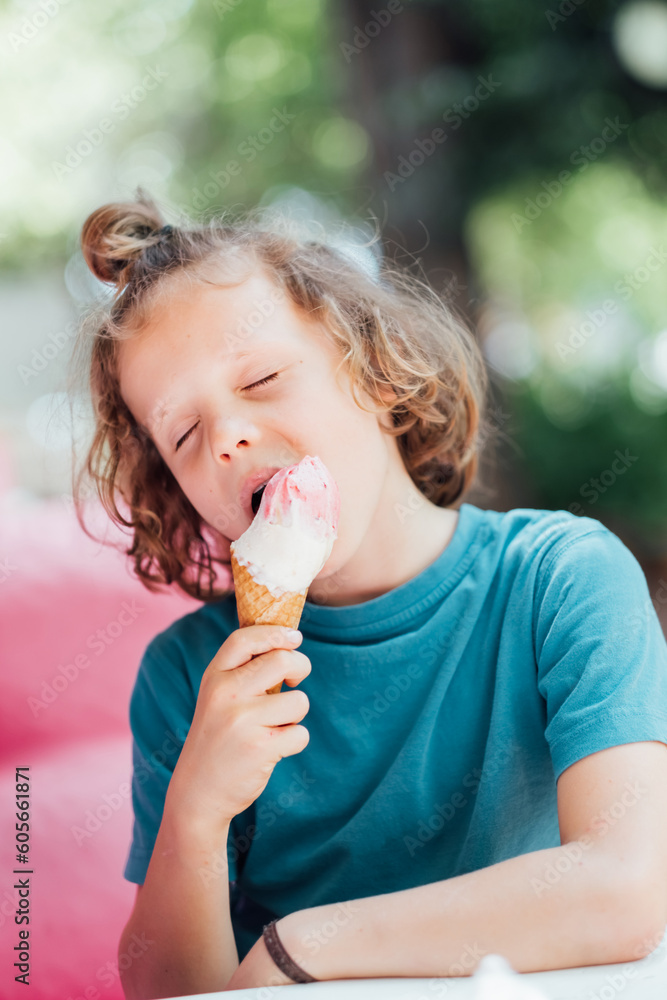 Cute curly boy eating cone ice cream. Child licking ice cream. Cute curly boy eating cone ice cream. Child licking ice cream.