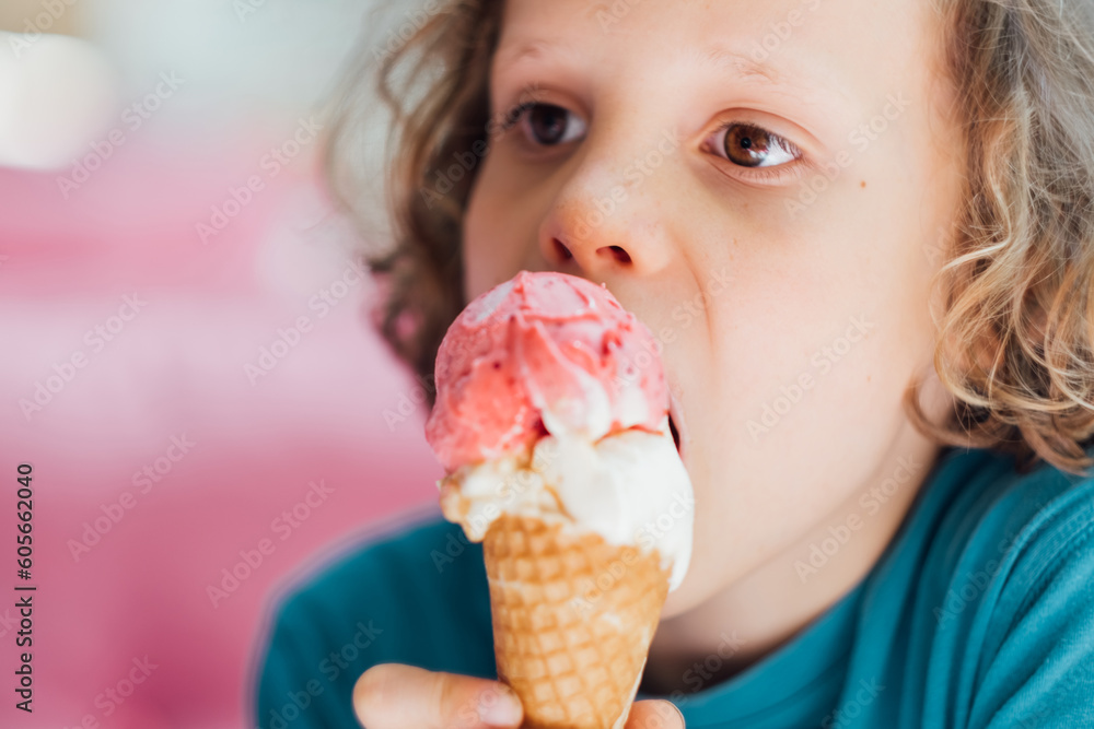 Closeup portrait of boy eating waffle cone ice cream with appetizing. Child licking ice cream.