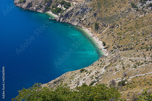A turquoise sea with a steep rocky shore