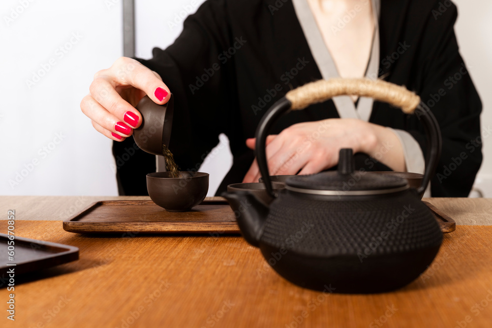 Attractive white girl in kimono and Hair sticks drinks tea in japanese style. Japanese tea ceremony. Attractive white girl in kimono and Hair sticks drinks tea in japanese style. Japanese tea ceremony.