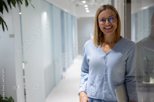 Joyous office employee with the computer standing in the corridor Free Download Joyous office employee with the computer standing in the corridor - GFXLoad