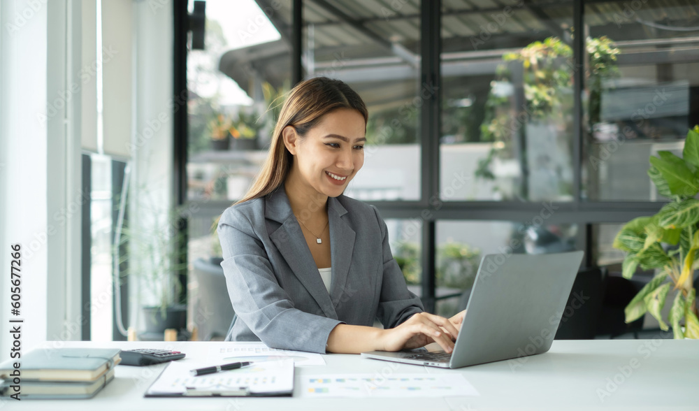 Asian businesswoman sit at their desks and calculate financial graphs showing results about their investments, planning successful business growth process Asian businesswoman sit at their desks and calculate financial graphs showing results about their investments, planning successful business growth process