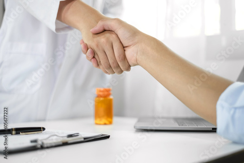 doctor and patient shaking hands in the hospital after finishing treatment. health care concept