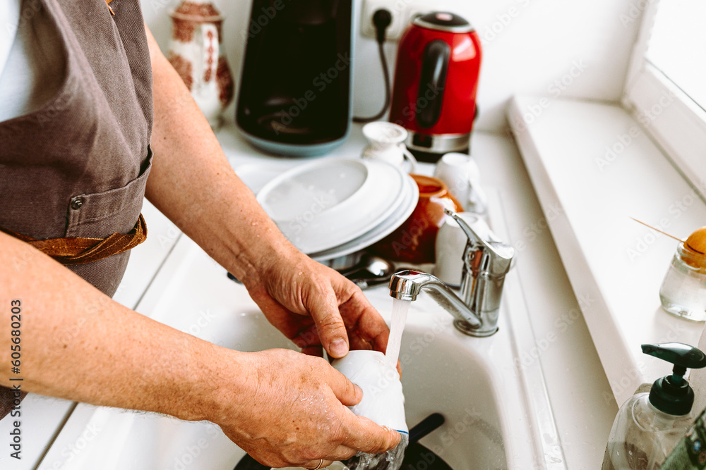 Male householder doing housework, washing dishes Male householder doing housework, washing dishes