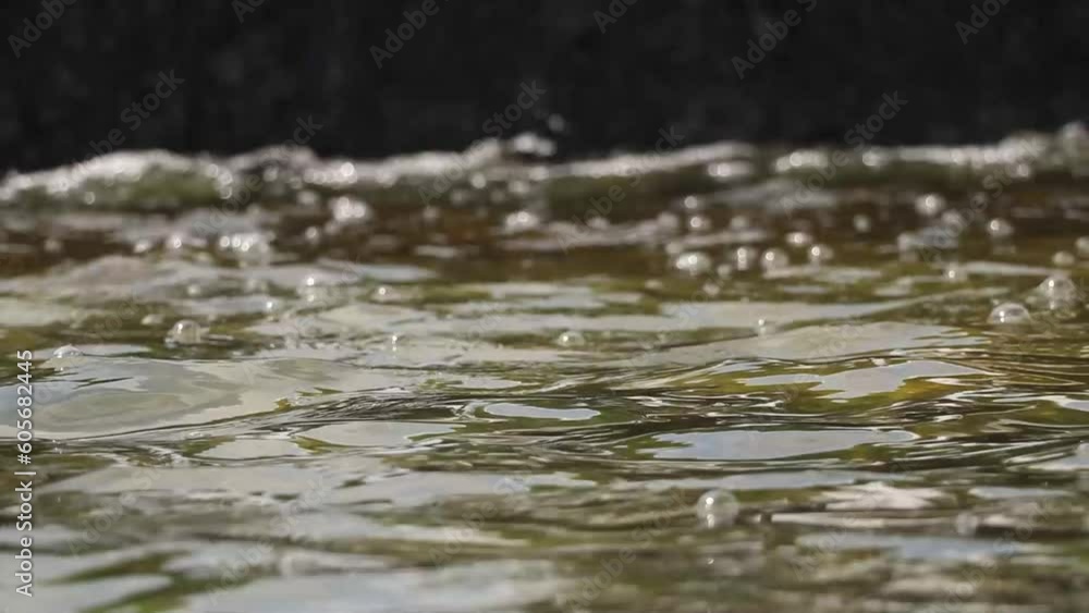City fountain in parks falls on stones and flows, video as background