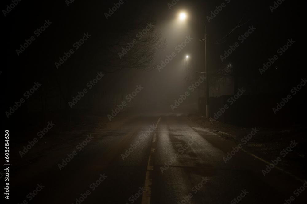 Road at night in fog. Fog on Schosse. Weak light on road in dark.