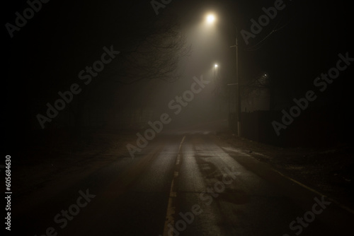 Road at night in fog. Fog on Schosse. Weak light on road in dark.
