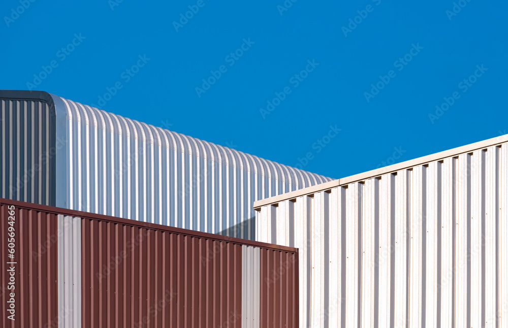 Corrugated metal industrial office buildings with aluminum warehouse against blue clear sky Background Corrugated metal industrial office buildings with aluminum warehouse against blue clear sky Background