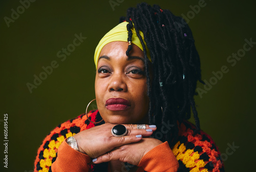 Portrait of lesbian woman with hands on chin against studio backdrop photo