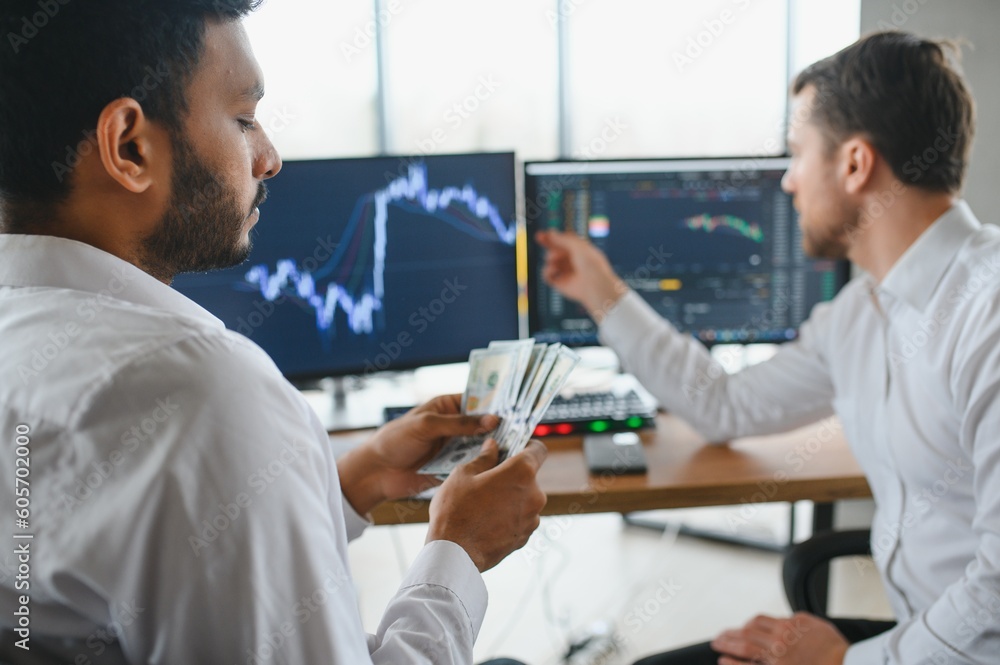 Obraz premium Two diverse business men analysts partners talking, working together, discussing data management using laptop computer. Indian manager consulting client with online technology at office meeting.