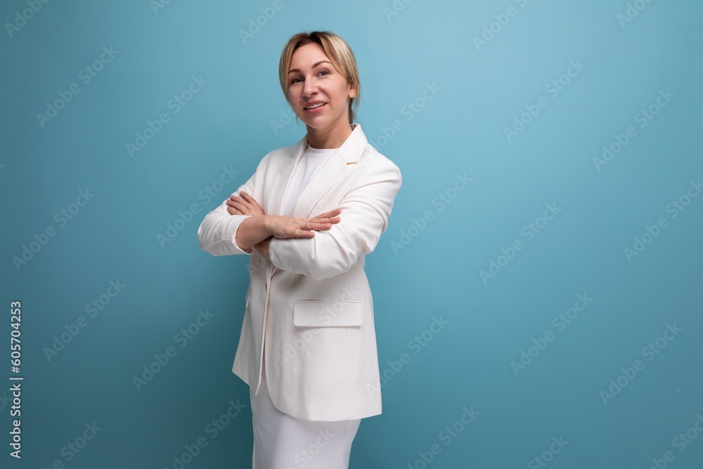 well-groomed slim young blond career woman in a white elegant jacket and skirt on a blue background with copy space well-groomed slim young blond career woman in a white elegant jacket and skirt on a blue background with copy space