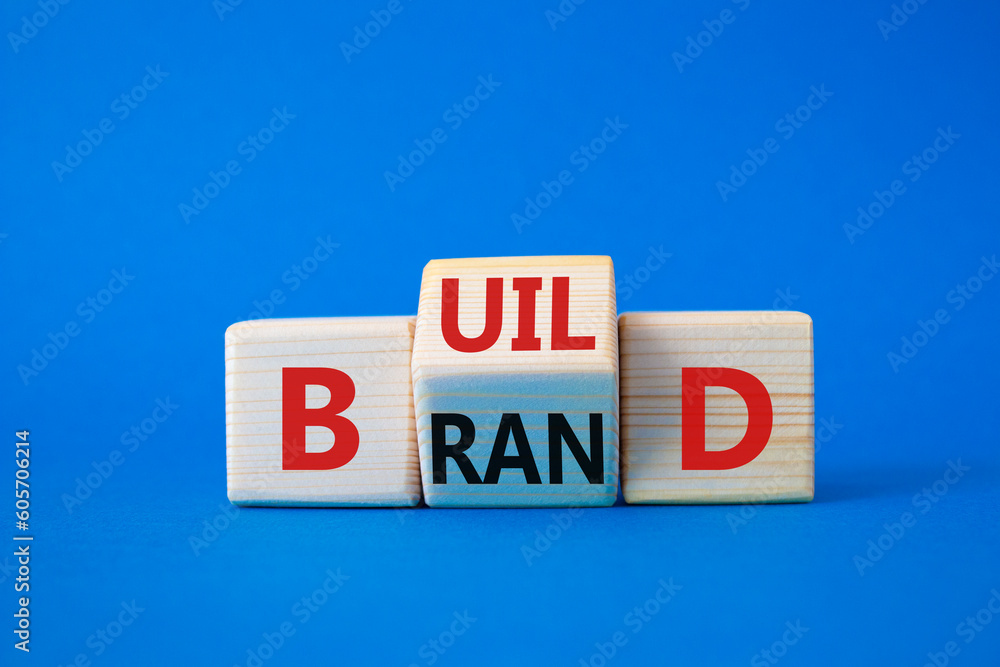 Build your brand symbol. Wooden cubes with words Build and Brand. Beautiful blue background. Build your brand and business concept. Copy space Build your brand symbol. Wooden cubes with words Build and Brand. Beautiful blue background. Build your brand and business concept. Copy space