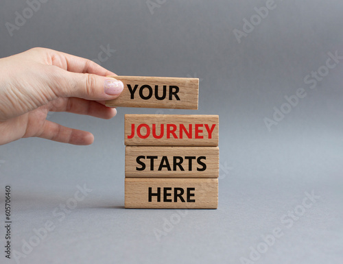 Your Journey starts here symbol. Concept word. Your Journey starts here on wooden blocks. Beautiful grey background. Businessman hand. Business and Your Journey starts here concept. Copy space