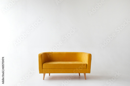 Fototapeta Naklejka Na Ścianę i Meble -  soft empty yellow sofa stands on white isolated background, comfortable fabric couch is alone against the white wall