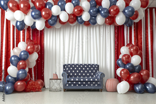 Patriotic stage decorations  red  white and blue balloons  stars and stripes of American flag  AI generative decorations with sofa for guests.