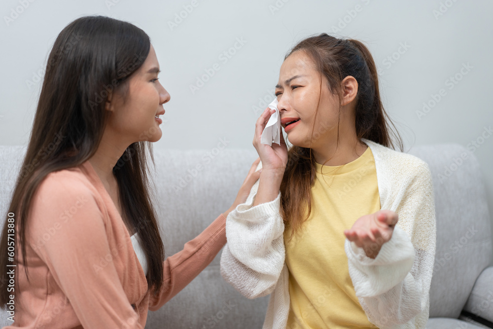 Two women talking about problems at home. Asian women embrace to calm their sad best friends from feeling down. Female friends supporting each other. Problems, friendship, and care concept Two women talking about problems at home. Asian women embrace to calm their sad best friends from feeling down. Female friends supporting each other. Problems, friendship, and care concept