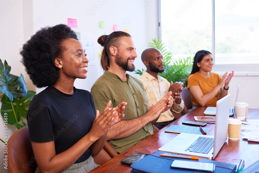 Obraz premium Four diverse team members clapping hands at meeting presentation, tech team
