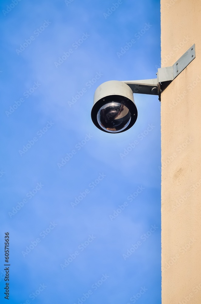 Municipal monitoring on the wall of the tenement house. Security camera on building against a blue sky background.