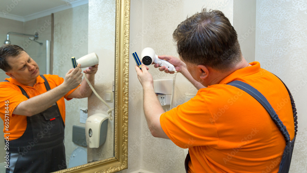 Man repairing hair dryer in bathroom. Man repairing hair dryer in bathroom.