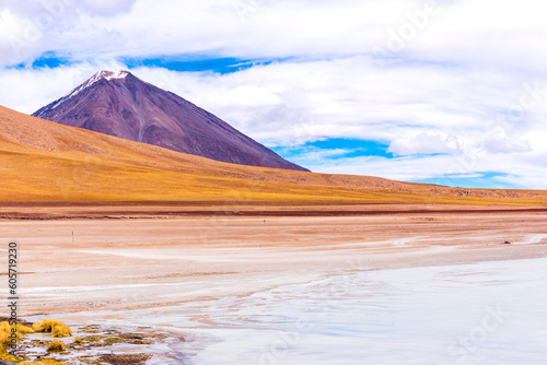 Volcano with snowy peak next to frozen lake in the Bolivian plateau