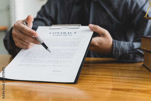 Lawyer working in a law office reading agreement contract documents and signing, Sign the auction documents.