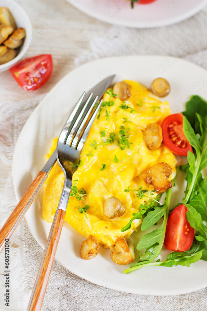 American scramble omelet with arugula, tomatoes and mushrooms. Breakfast